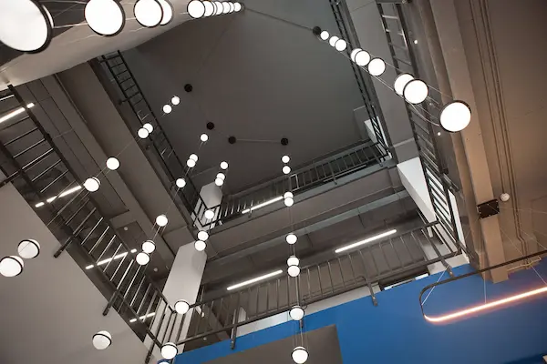 сферические светильники на подвесах установленные на потолке с большой высотой в офисном здании