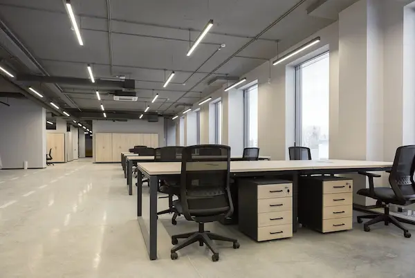 линейные светильники в офисном пространстве над столиками