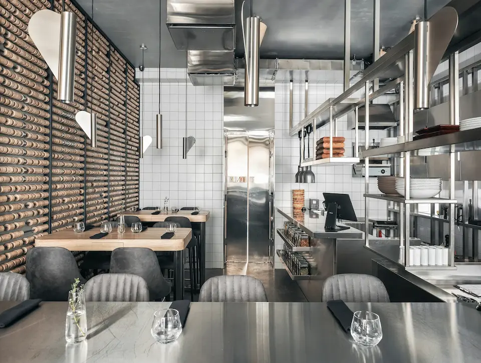 металлические светильники из нержавейки в интерьере ресторана Birch на фоне кухни