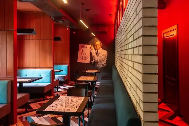 интерьере ресторана Frank в красных тонах со стеной из белого кирпича и черными металлическими подвесными светильниками