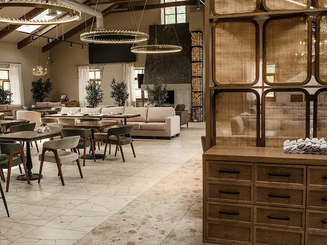 три золотые круглые люстры в виде рингов с хрусталиками в интерьере ресторана