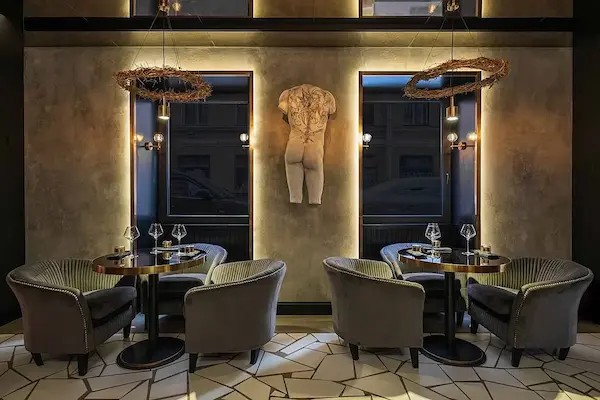 уютное освещение необычными золотыми подвесными светильниками над столиками ресторана Gods