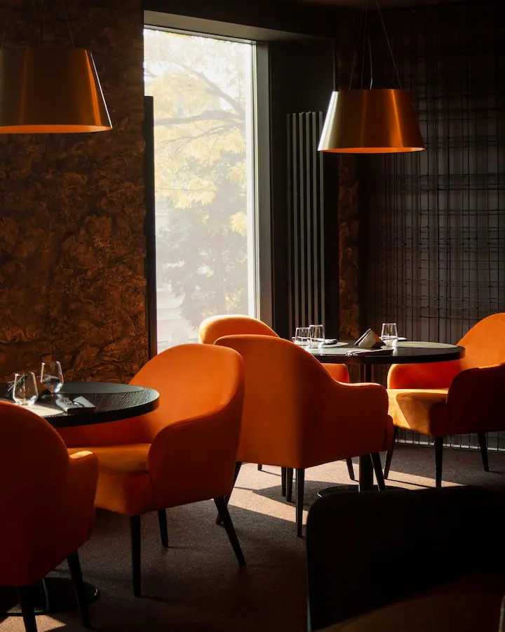 латунные металлические абажуры трапецевидной формы над столиками в ресторане Jam