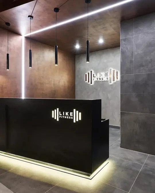 светильники трубочки черного цвета над ресепшеном в спортивном клубе