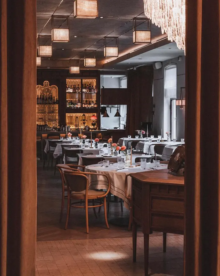 современный интерьер ресторана с прямоугольными потолочными светильниками из латуни и оникса с приглушенным светом