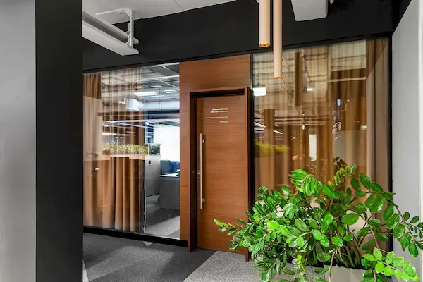 бежевые светильники трубочки в интерьере офиса со стекляными стенами