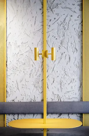 желтые дизайнерские светильники бра над металлическим столиком в ресторане Pobo