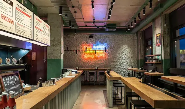 интерьер мясного кафе с множеством черных потолочных светильников с галогеновыми лампочками